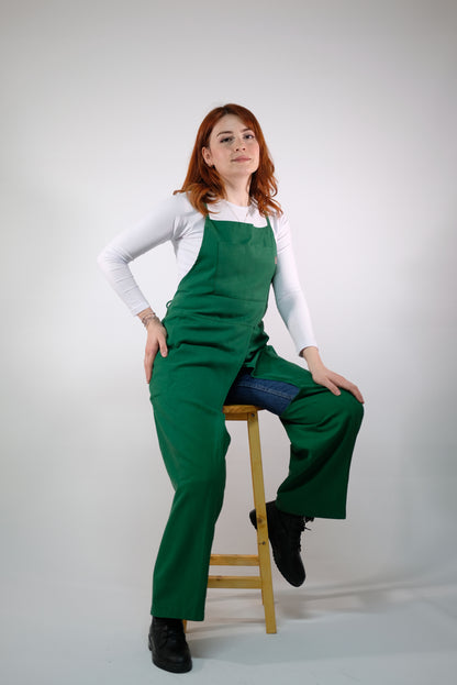 Green apron with split leg feature laid flat on white background.