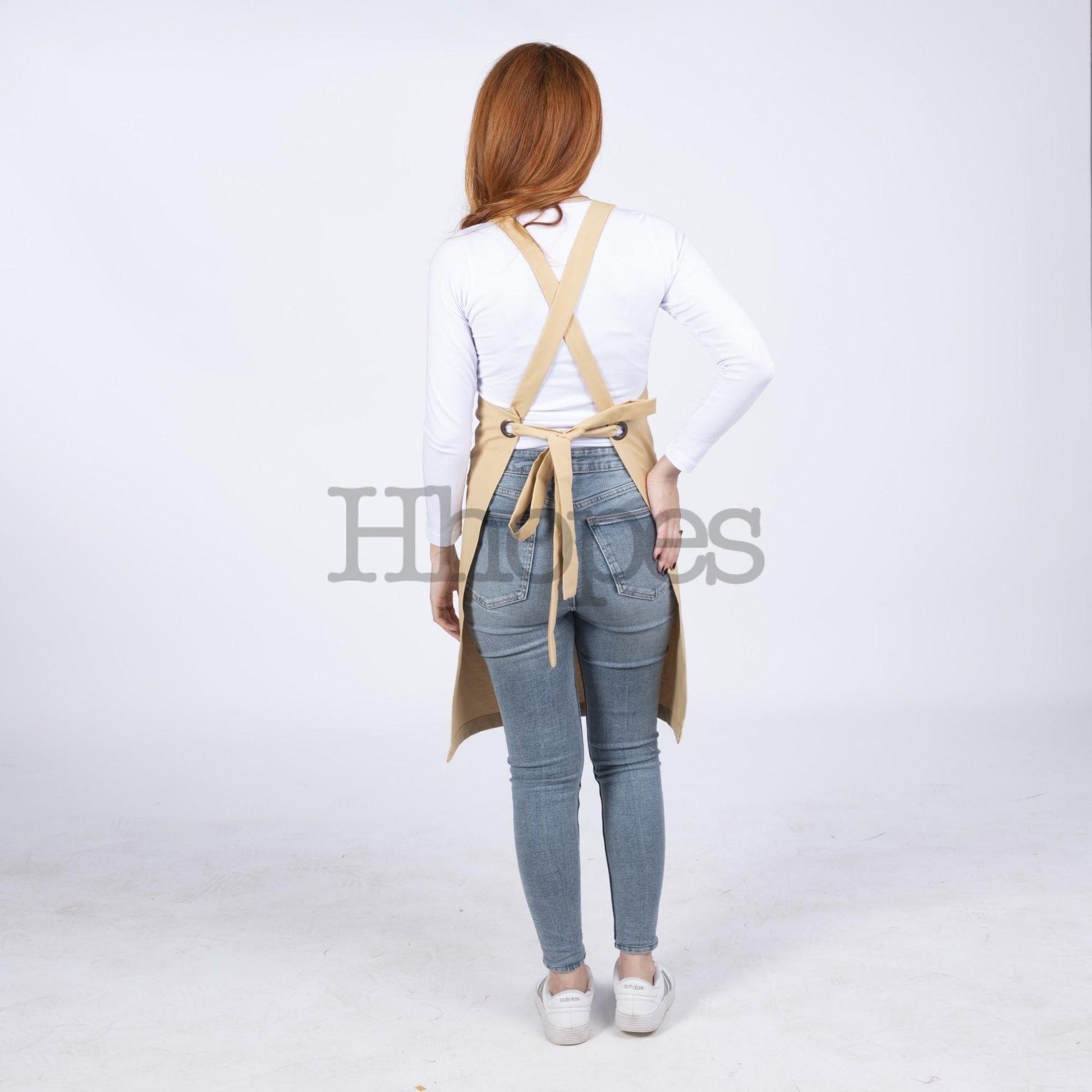 Custom logo option displayed on mustard cross-back apron.