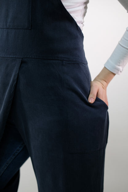 Styled photo: jumpsuit apron next to ceramic pots.